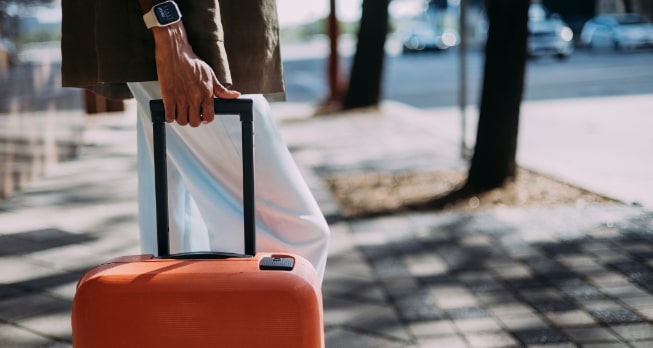 Gepäckservice in der Business Class - Ein Koffer wird durch eine sommerliche Stadt gezogen